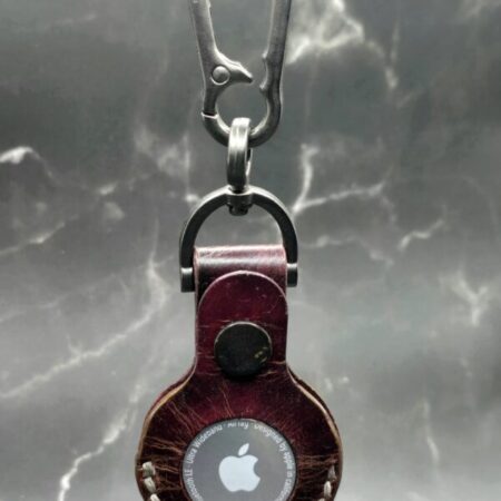 Burgundy-Brown Leather Apple Air Tag Case with stamped skull and crossbones on a lobster clasp keychain