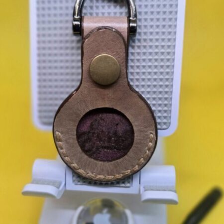 Light brown leather Apple air tag cover.