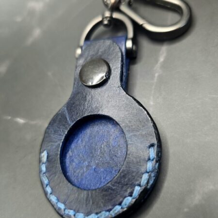 Navy blue leather Apple AirTag on a lobster clasp keychain.