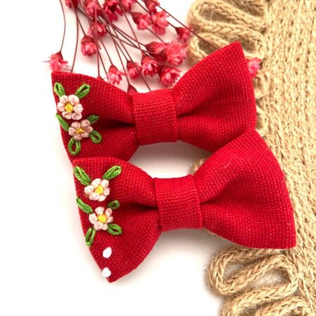 Hand-embroidered classic red linen bows with ivory floral embroidery from Thread & Stitch Studio.
