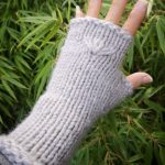 in a chic pumice stone grey, these gloves feature a unique hand-knitted texture that adds a touch of warmth and charm to any outfit. Available in 8" or 9 inches length, they provide ample coverage while allowing for freedom of movement, making them perfect for everything from chilly walks to cozy nights by the fire. Handmade with love in beautiful British Columbia, Canada, each pair is a testament to quality craftsmanship and eco-conscious living. Embrace both style and sustainability with these fingerless gloves—your hands will thank you!