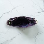 A Slouchy multi pockets eggplant color bag with iridescent hardware and decorative zipper tassels