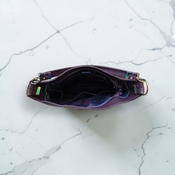 A Slouchy multi pockets eggplant color bag with iridescent hardware and decorative zipper tassels