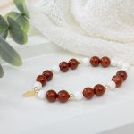 Handcrafted red jasper and magnesite beaded bracelet with 14K gold beads and a gold filled leaf charm centerpiece