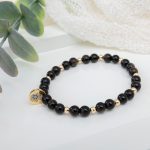 Black obsidian beaded bracelet with 14K gold filled Hamsa hand charm and blue cubic zirconia accent